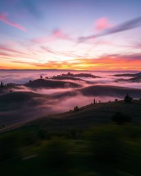 Long-exposure photograph: Tuscan sunset over misty rolling hills, electric vivid colors, motion blur, light trails, dynamic c