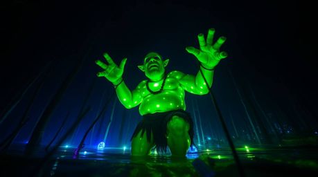 A captivating scene of a luminous green ogre dancing in a vibrant swamp at night.  Low-angle perspective showcases the biolum