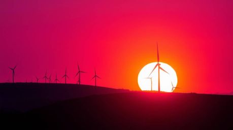 Explore a stunning fine art photography series capturing the mesmerizing sunset behind wind turbines perched atop a rolling h