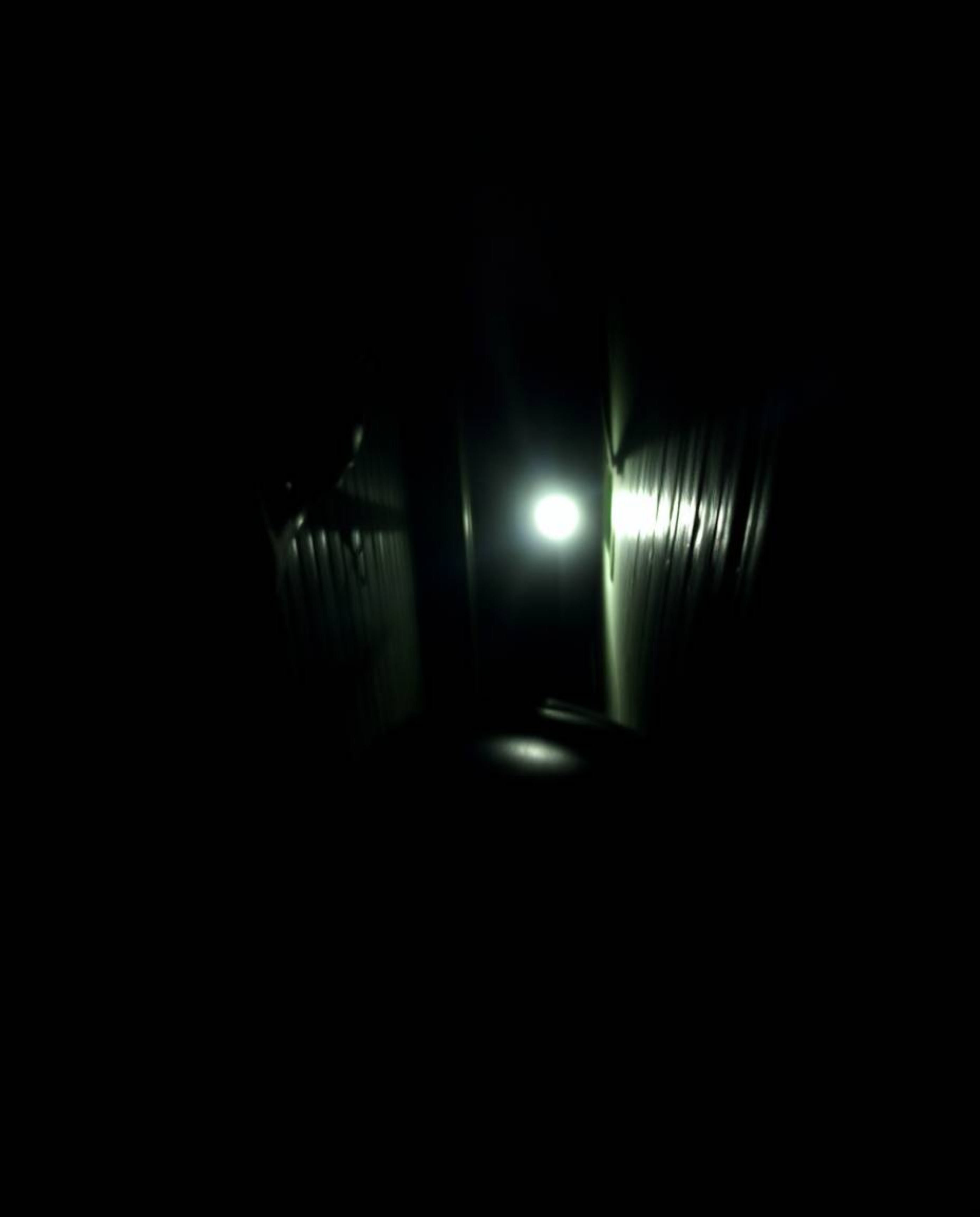 A moody and dramatic scene captured with a low-angle perspective, showing a pair of eyes watching from the shadows of a night