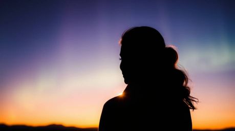 A captivating image featuring rich burgundy and deep blue tones.  The subject is silhouetted against a stunning backdrop of a