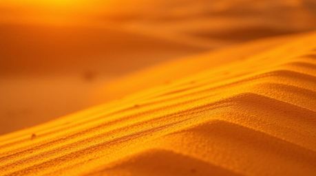Capture the breathtaking beauty of a desert sunset in extreme macro close-up, showcasing golden dunes bathed in the warm glow
