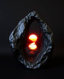 An intensely black, cast bronze sculpture depicting a glassy fjord reflecting a sunset. The piece is distinguished by its pur