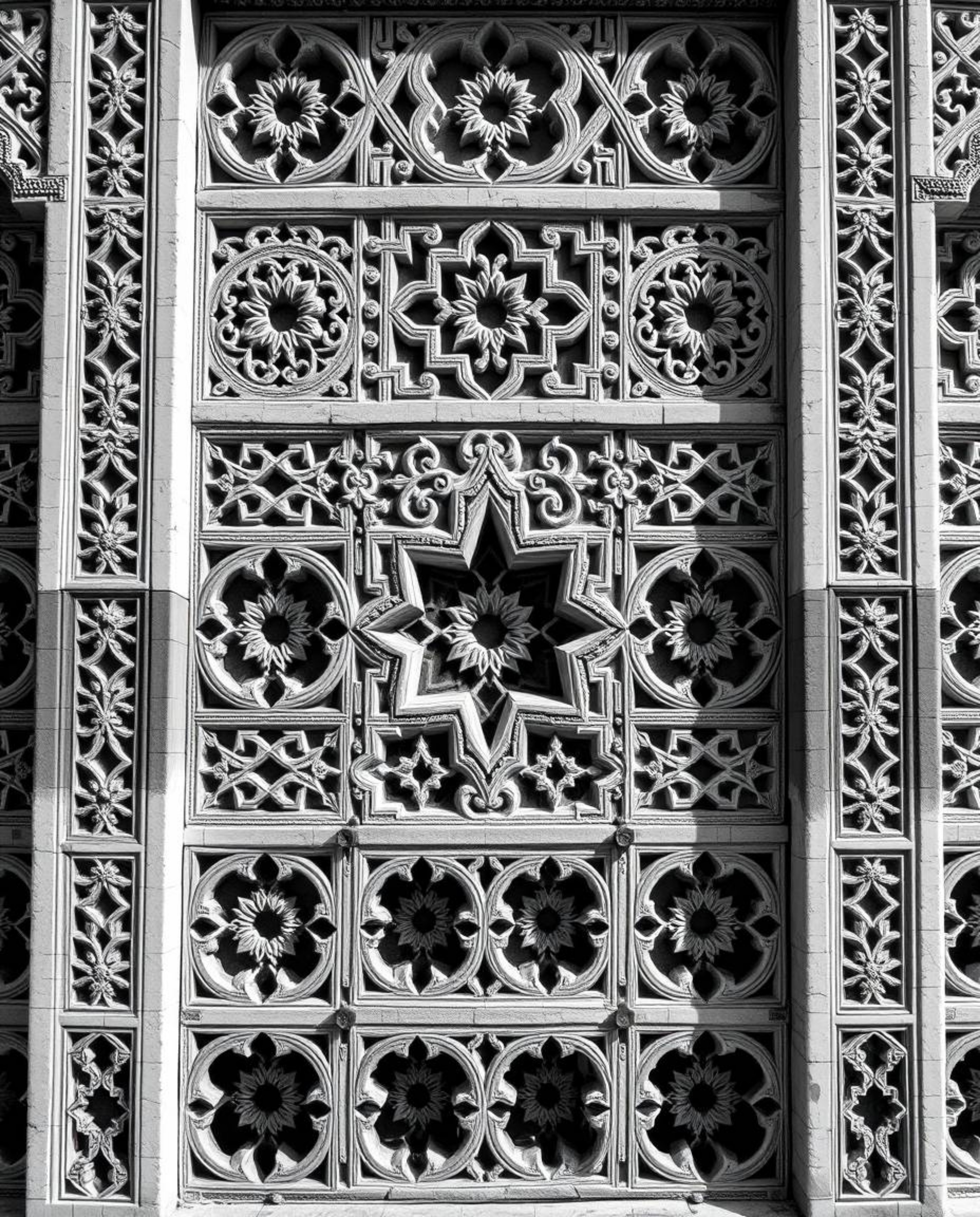 This artwork features classic black and white imagery showcasing intricate Islamic geometric patterns carved into stone. The