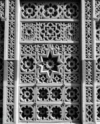 This artwork features classic black and white imagery showcasing intricate Islamic geometric patterns carved into stone. The 