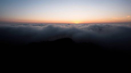 Experience the breathtaking beauty of a foggy sunset landscape. This image showcases dramatic chiaroscuro lighting, with stro