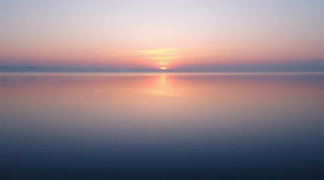 A captivating image showcasing a lake serenely reflecting the vibrant hues of a pastel or vivid sunset sky. The scene evokes 