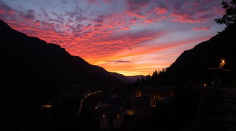 Experience the tranquility of a cozy village nestled in a picturesque valley.  Bathed in the warm glow of a colorful sunset a