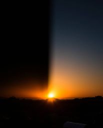 Experience the stark beauty of a sunrise over a war-torn landscape, rendered in dramatic chiaroscuro lighting and a distinct 