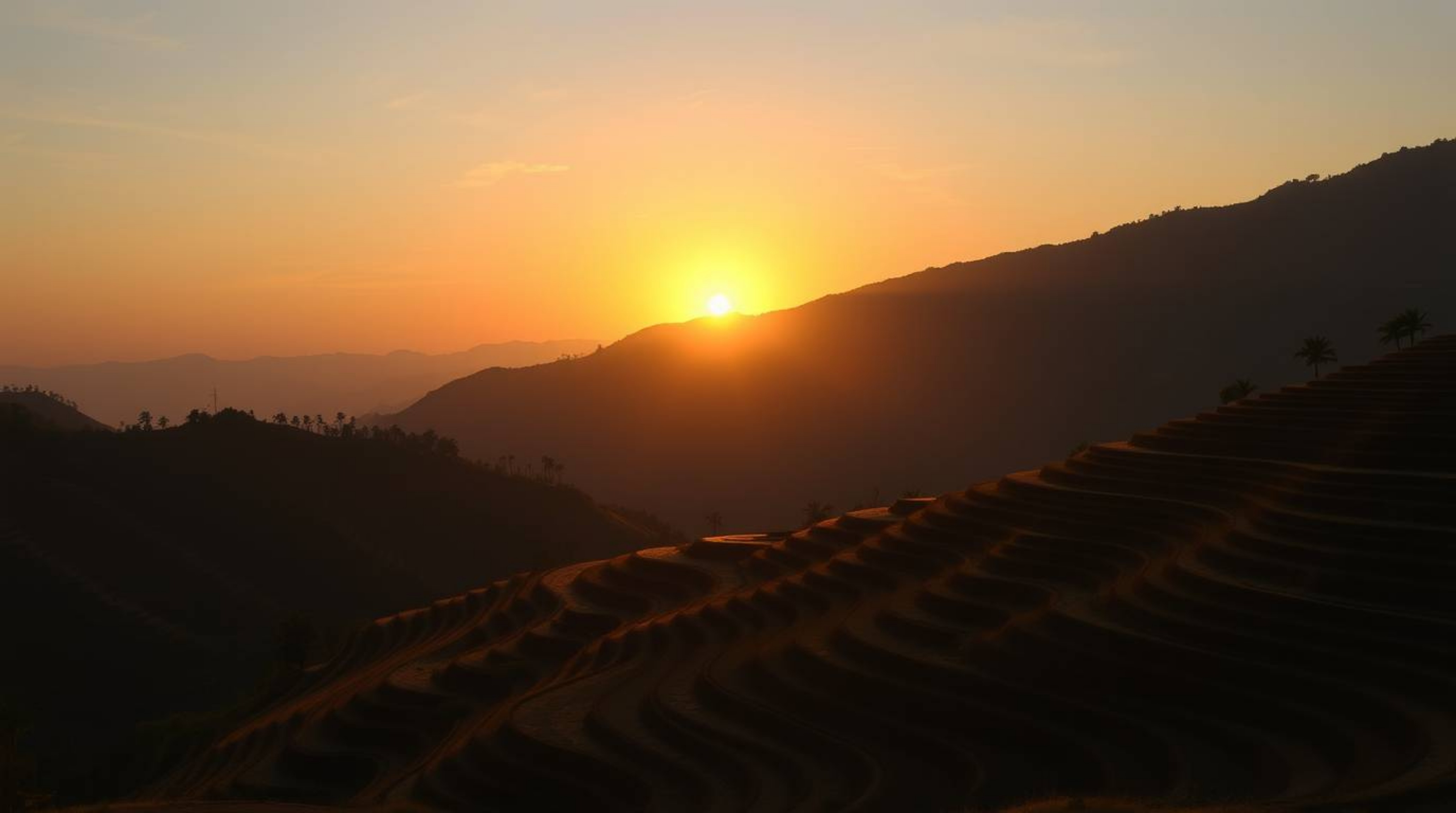 A breathtaking scene of a sunset over rice terraces in the mountains is captured with a seamless gradient transition. Strong,