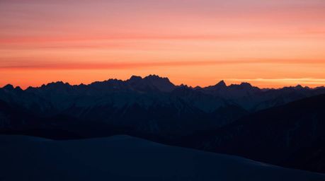 Experience the serene beauty of snow-capped mountains bathed in the warm glow of a pastel sunset.  This sophisticated image f