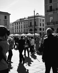 A captivating black and white street photograph depicts a spontaneous musical performance in a vibrant town square.  Deep sha