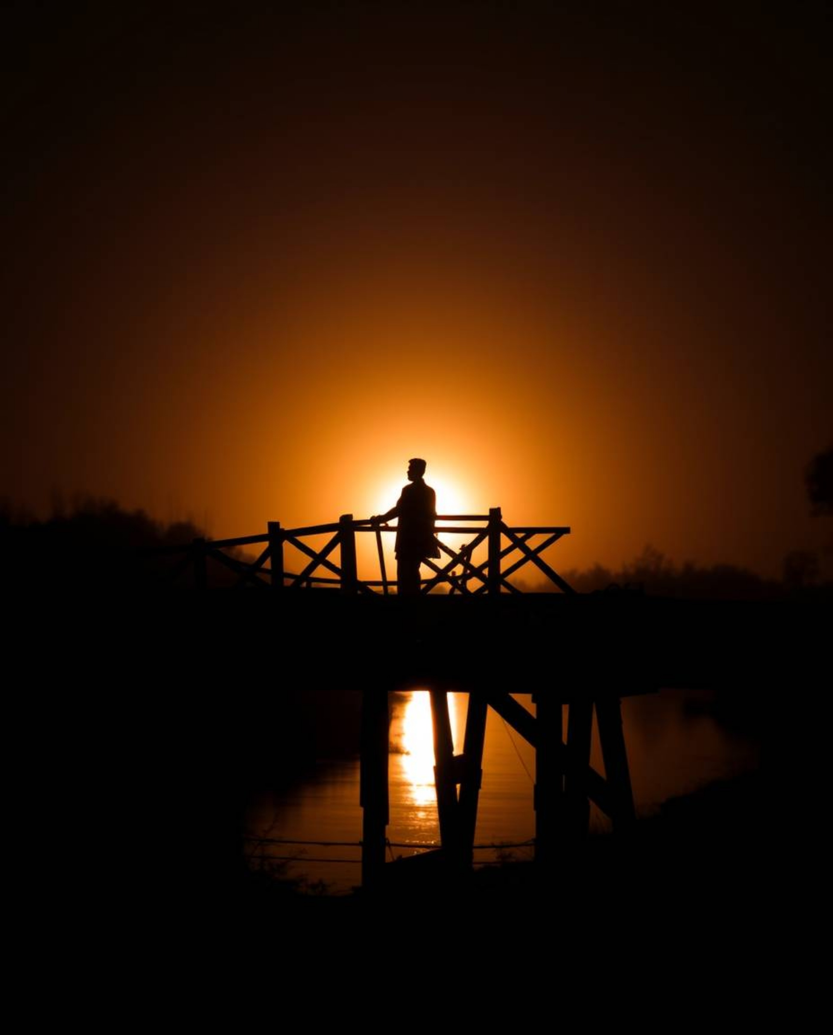 An unusual and original piece of fine art, this warm and slightly dark professional photograph captures an old wooden bridge 