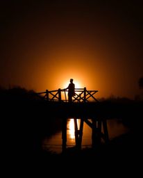 An unusual and original piece of fine art, this warm and slightly dark professional photograph captures an old wooden bridge 