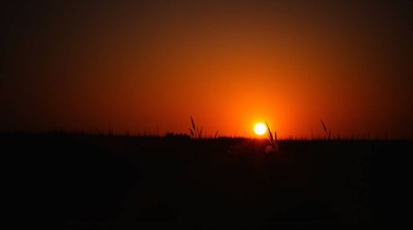 Experience the magic of a high-contrast, low-key cinematic scene.  A breathtaking sunset casts deep shadows across a quiet me