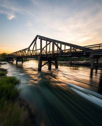 An extreme macro close-up captures the intricate details of an old wooden bridge over a river at sunset. The image is rendere
