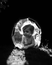 A captivating black and white image depicts a child's serene discovery of a magical portal hidden in their backyard. The gen