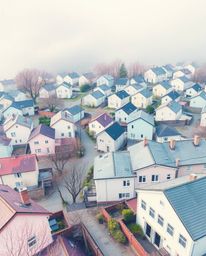 This captivating watercolor painting captures a sleepy town bathed in pastel hues, rendered with an otherworldly feel through