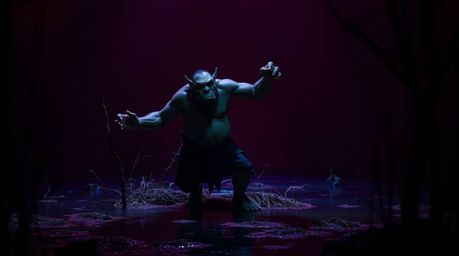 A captivating image of an ogre dancing in a swamp, illuminated by a striking contrast of burgundy and deep blue.  The high co