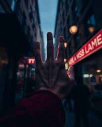 Captivating street photography showcasing rich burgundy and deep blue tones in candid urban scenes. Focus is drawn to a hand 