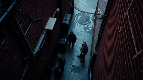 A captivating overhead shot of a grungy city alley, showcasing rebellious teenagers.  The image boasts rich burgundy and deep
