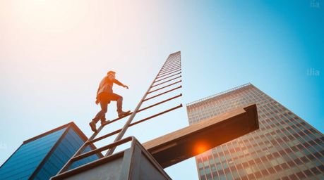 An abstract image depicting the concept of success. A cast bronze figure, bathed in warm golden hour light, climbs a transpar