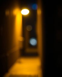 An evocative image capturing eyes watching from the darkness of a shadowed alley at night. Rendered with a beautiful blurred 