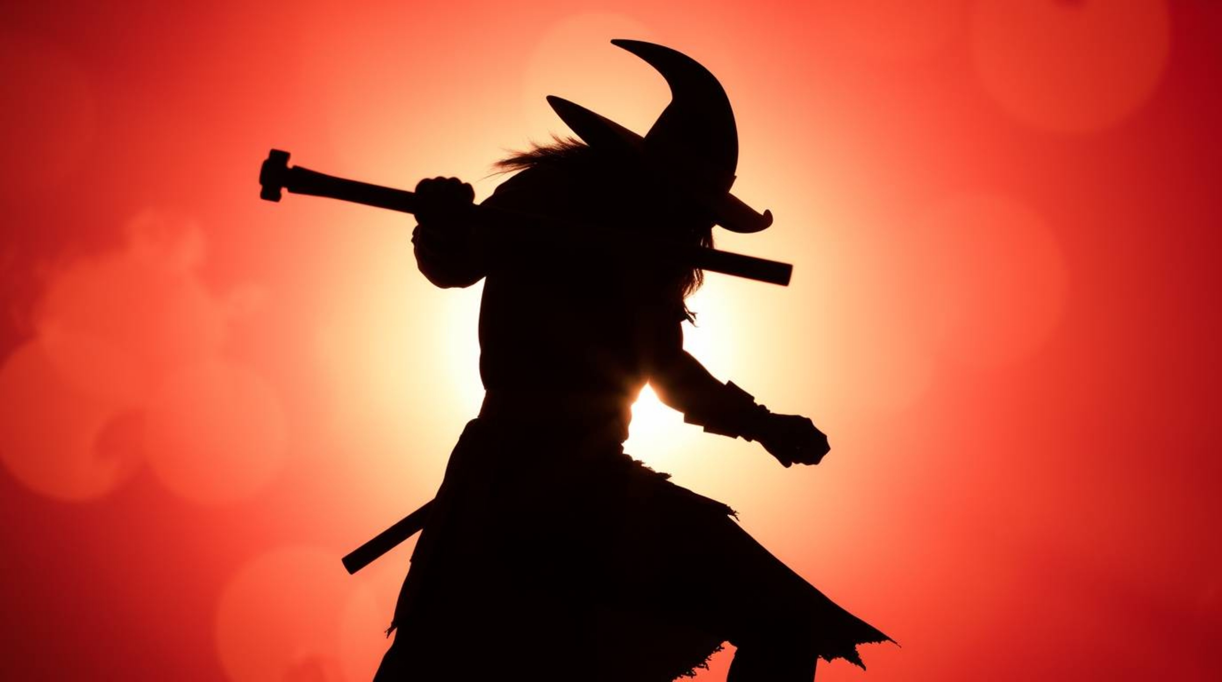 A silhouetted anvil poised to strike a trickster character, bathed in the vibrant colors created by backlighting. The energet