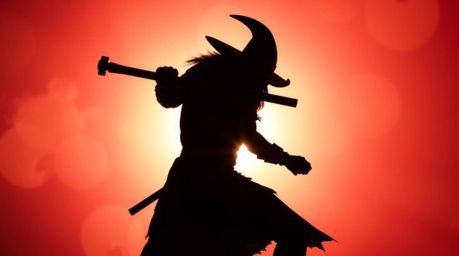 A silhouetted anvil poised to strike a trickster character, bathed in the vibrant colors created by backlighting. The energet