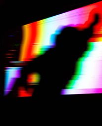 This image showcases intense jet black, high contrast, low key lighting dramatically highlighting a TV screen glitch.  The re