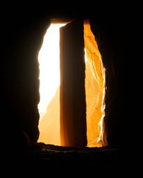 Explore the mystery of an ancient doorway adorned with glowing runes, nestled within a mountainside, captured with warm, soft