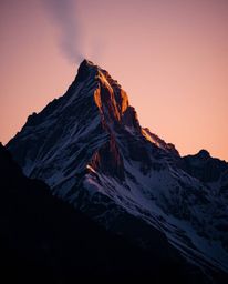 Witness a high alpine peak sunset defined by intense dramatic lighting and high contrast. This composition is both graceful a