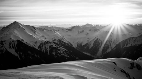 A stunning close-up captures the timeless elegance of snow-capped mountains bathed in the warm glow of a sunset.  The black a