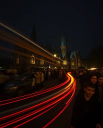 A captivating long exposure photograph showcases a magical school at night, filled with young wizards. Motion-blurred light