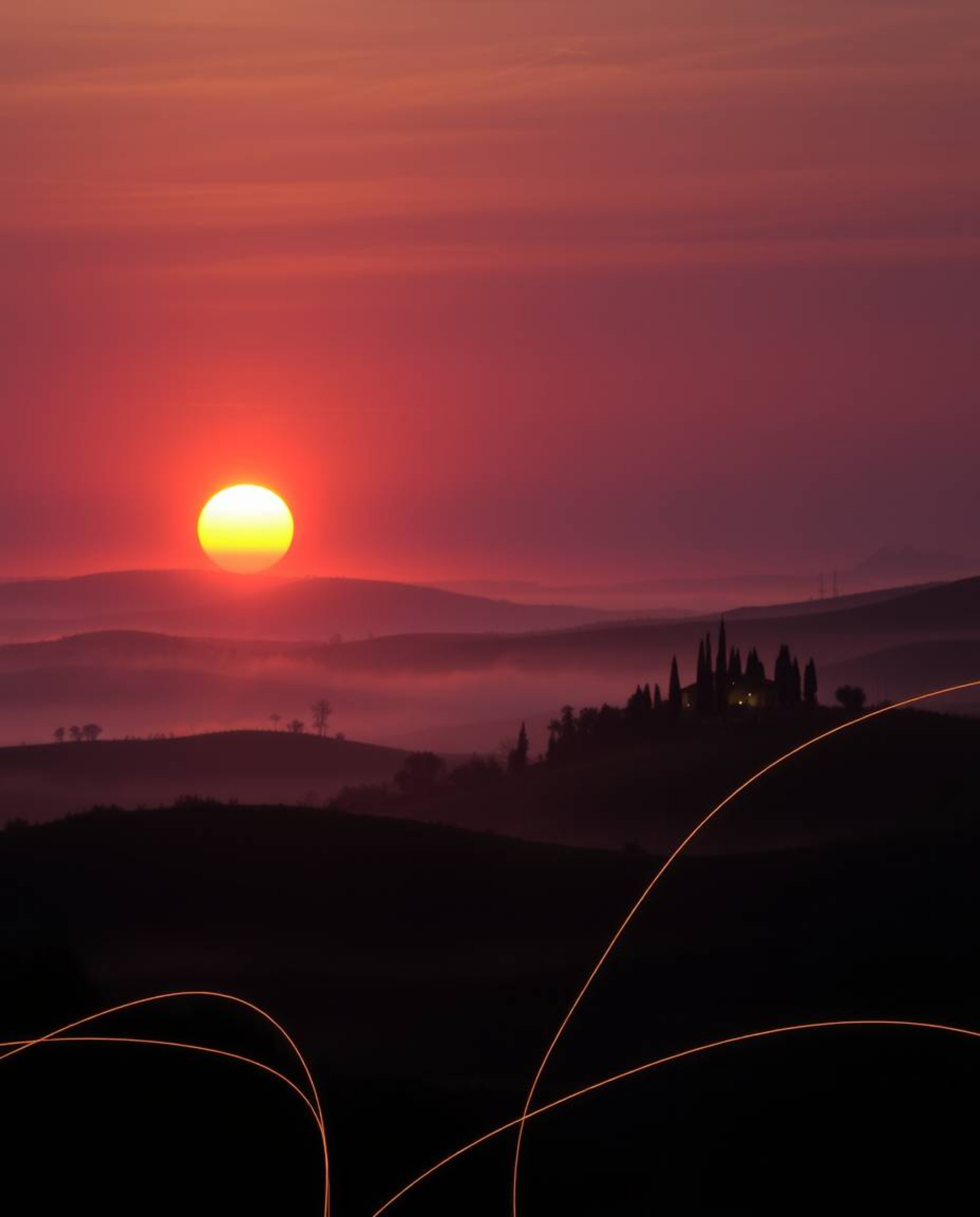 This is a creative light art piece depicting a sunset over the misty, rolling hills of Tuscany. The artwork employs artistic 