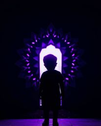 A captivating image depicts a child silhouetted against a vibrant, deep ultraviolet portal in their backyard.  The scene is r