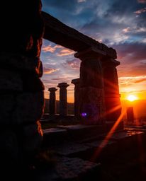 Experience the mesmerizing sight of ancient stone ruins at sunset, dramatically casting long shadows. This artwork is brought