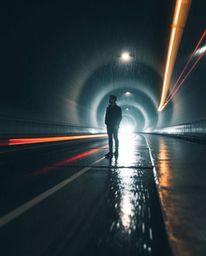 A captivating long-exposure photograph showcasing a lone figure standing at the tunnel's edge, gazing towards a distant light