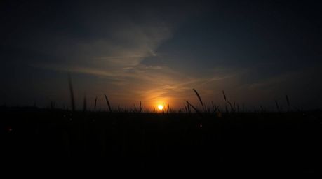 Experience the magic of a high-contrast, low-key sunset photograph.  This stunning image captures the serene beauty of a quie