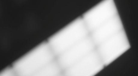 This abstract composition features a high contrast, low-key lighting scheme casting deep shadows across an abstract gradient 