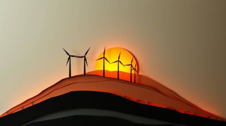 A captivating papier-mâché sculpture portrays a breathtaking sunset behind a line of wind turbines perched on a hill.  The hi