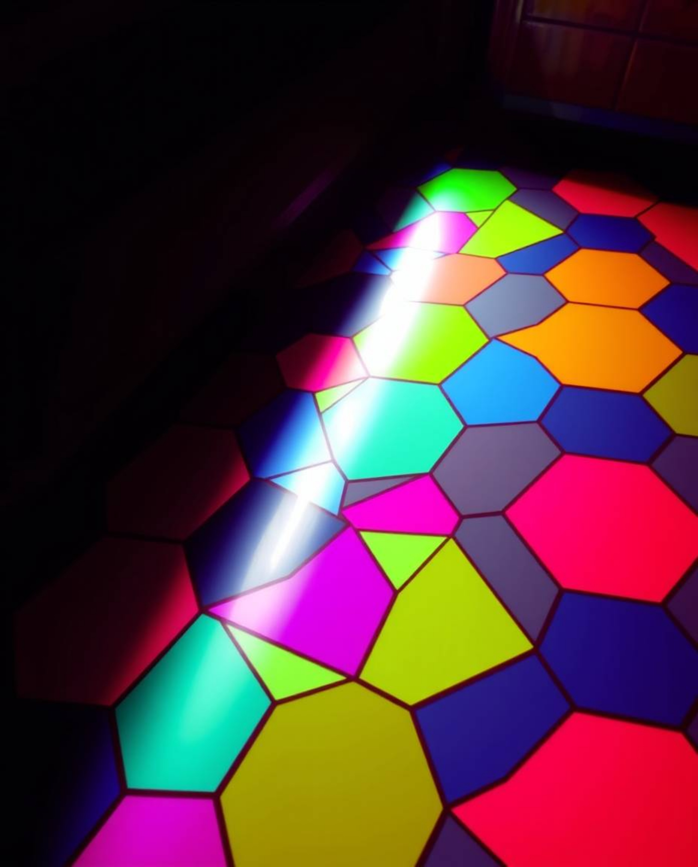 This high-angle photograph showcases a captivating seamless geometric pattern of hexagons and triangles, rendered in a vibran