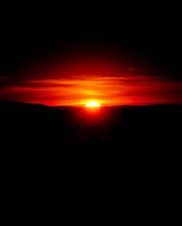 This abstract artistic light art piece reimagines a sunset over a vineyard as a dramatic, jet black event. The composition is