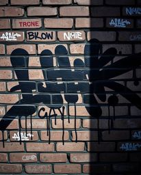 Explore an intense image showcasing jet black graffiti-style colorful splashes dramatically adorning a brick wall, capturing 