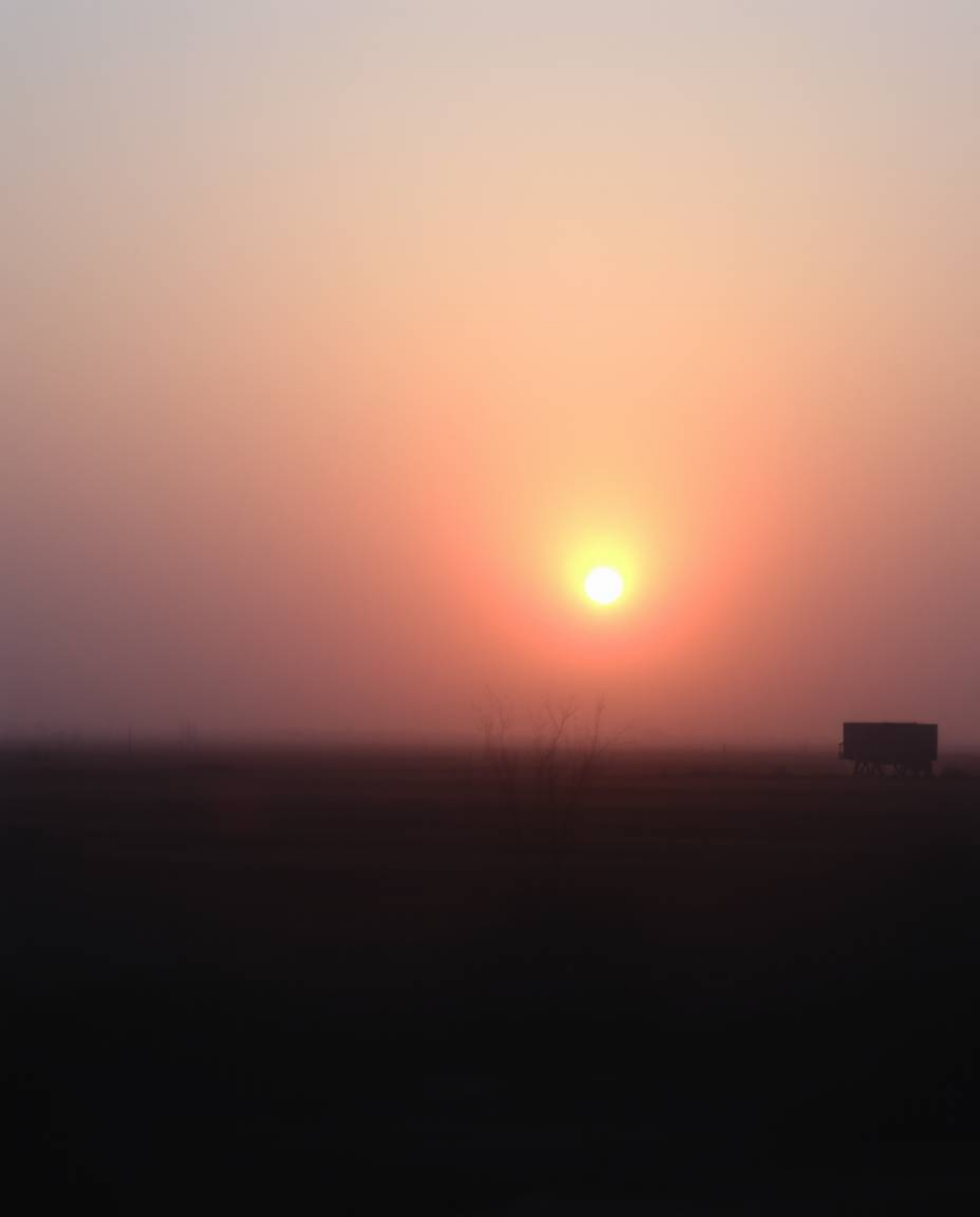 Capture the surreal beauty of a sunrise over a war-torn landscape. This image features soft, dreamy atmospheric effects, irid