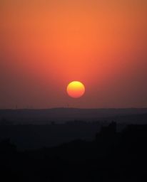 A breathtaking fine art photograph captures a sunrise over a war-torn landscape.  The image, reminiscent of Associated Press 