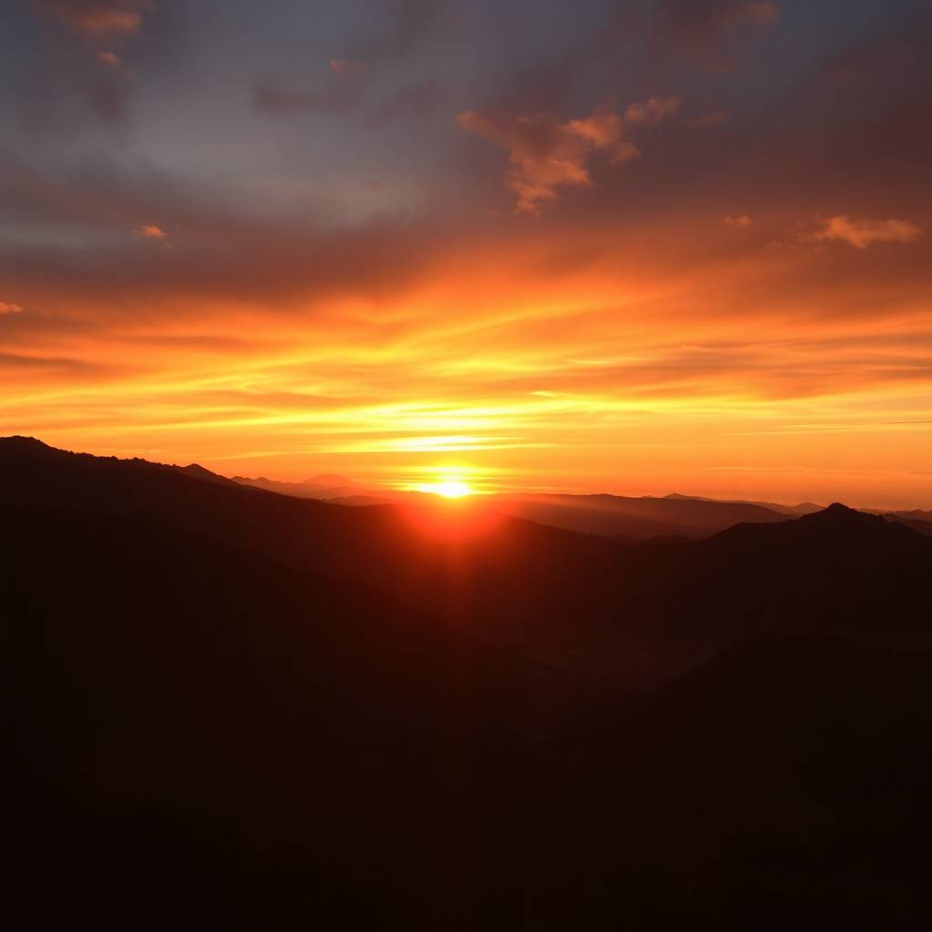 This stunning architectural color photograph captures a breathtaking sunset over a serene mountain valley. The image utilizes