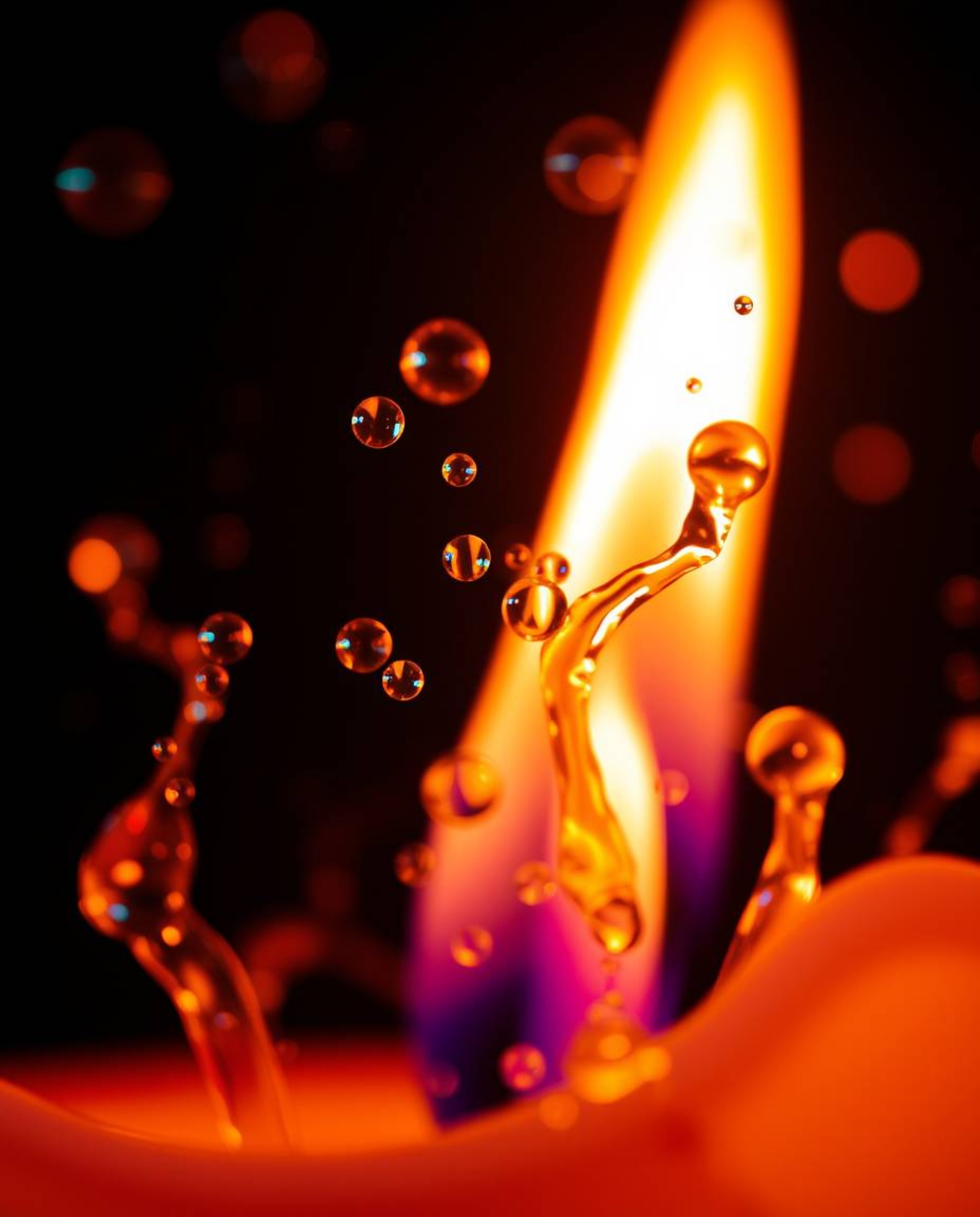 Explore the mesmerizing world of extreme macro photography featuring warm candlelight and iridescent colors dancing on a blac