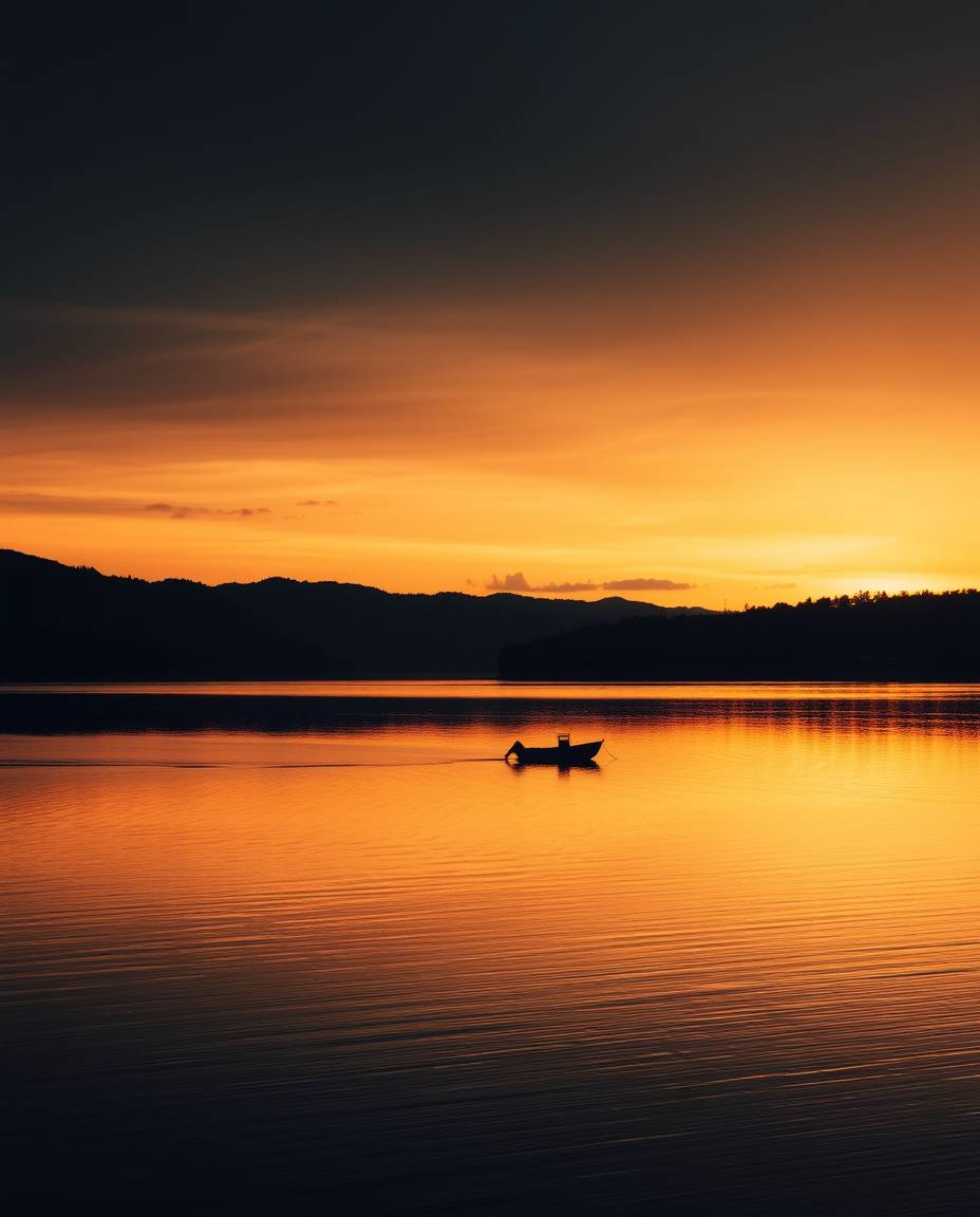 A lone boat drifts on a still lake at sunset, rendered in intense jet black with deep shadows, emphasizing the contrast betwe