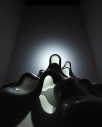 Silhouetted backlighting and a low-angle perspective accentuate sculptural 3D fluid mercury shapes with reflective surfaces u